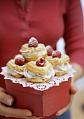 Profiteroles with raspberry cream on gift box