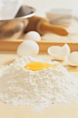 A pile of flour with eggs (baking ingredients)