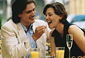 Paar in einem Strassencafe, Oliven essend, Brustbild