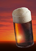 Glass of Altbier in front of  sunset (collage)