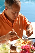 Brasilianer isst Camarao na Moranga (Kürbis-Shrimps-Gericht)