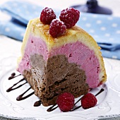 A piece of chocolate and raspberry iced bombe