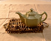 Tea measuring spoon with black tea mixture and a teapot