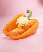 Half a yellow pepper on pink background