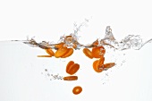Carrot slices falling into water