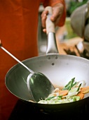 Stir-frying vegetables in wok