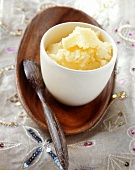 Ghee (clarified butter; India) in small bowl with wooden spoon