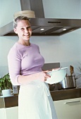 Young woman in kitchen with soup bowl