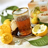 Bergamotten-Tee im Teeglas, frische Bergamotten daneben