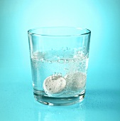 Glas Wasser mit zwei Aspirin-Brausetabletten