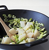Stir-frying fish and vegetables in wok