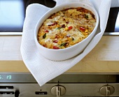 Rice and vegetable bake in white baking dish on cooker