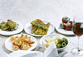 Various Mediterranean appetisers with glass of red wine