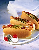 Hot Dogs mit Zwiebeln, Essiggurken und Ketchup