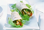 Chicken wraps with peppers on lettuce leaves