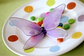 Coloured plate with chocolate beans and tulle butterfly