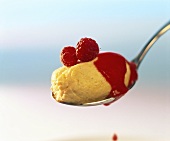 Mango mousse with raspberry puree and raspberries on spoon
