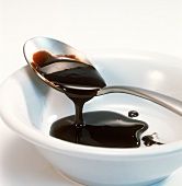 Molasses running from spoon into a bowl