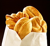 White rolls and croissant in paper bag