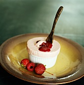 Strawberry ice cream soufflé with berry sauce in mould