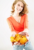 Junge Frau hält Kartoffelchips in den Händen