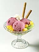 Three scoops of cherry ice cream & exotic fruit in sundae glass