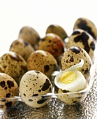 Twelve quail's eggs, one boiled and opened