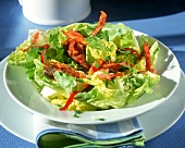 Lettuce with strips of fried bacon and poultry liver
