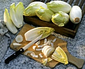 Chicory with knife on a wooden board