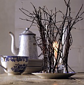 Candle in glass with twigs as winter table decoration