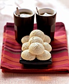 Amaretti (almond macaroons) in front of 2 mugs of white coffee