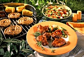 Barbecued chicken wings, sausages and corncobs