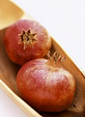 Two pomegranates in wooden bowl