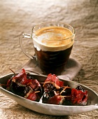 Plums wrapped in bacon and a glass of Irish Coffee