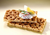 Two slices of sesame crispbread with herb quark and egg