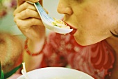 Woman eating Asian chicken & vegetable soup (surreal photo)