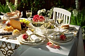 Laid table with roses, cheese platter, olives etc.
