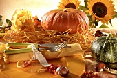 Place-setting in warm orange shades with autumn decorations