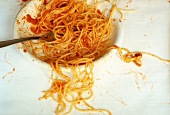 Halb leer gegessener Teller Spaghetti mit Tomatensauce