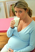 Pregnant woman drinking glass of milk (grainy effect)