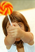 Small girl holding coloured lollipop (grainy effect)