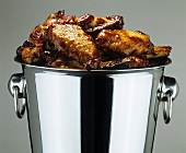 Chicken wings with spicy honey glaze in a champagne bucket