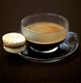 Espresso in glass cup and a biscuit with chocolate cream