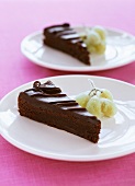 Two pieces of chocolate cake on plates