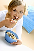 Young woman eating muesli with fresh blueberries