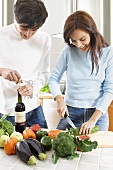 Junges Paar in der Küche, Frau schneidet Gemüse klein