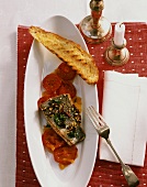 Fried sea bass fillet on tomato slices
