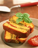 Two pieces of savoury cake filled with tomatoes & pesto cream