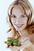 Blond woman holding three limes in her hand