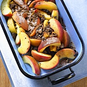 Apple wedges with sugar and chocolate in a baking dish